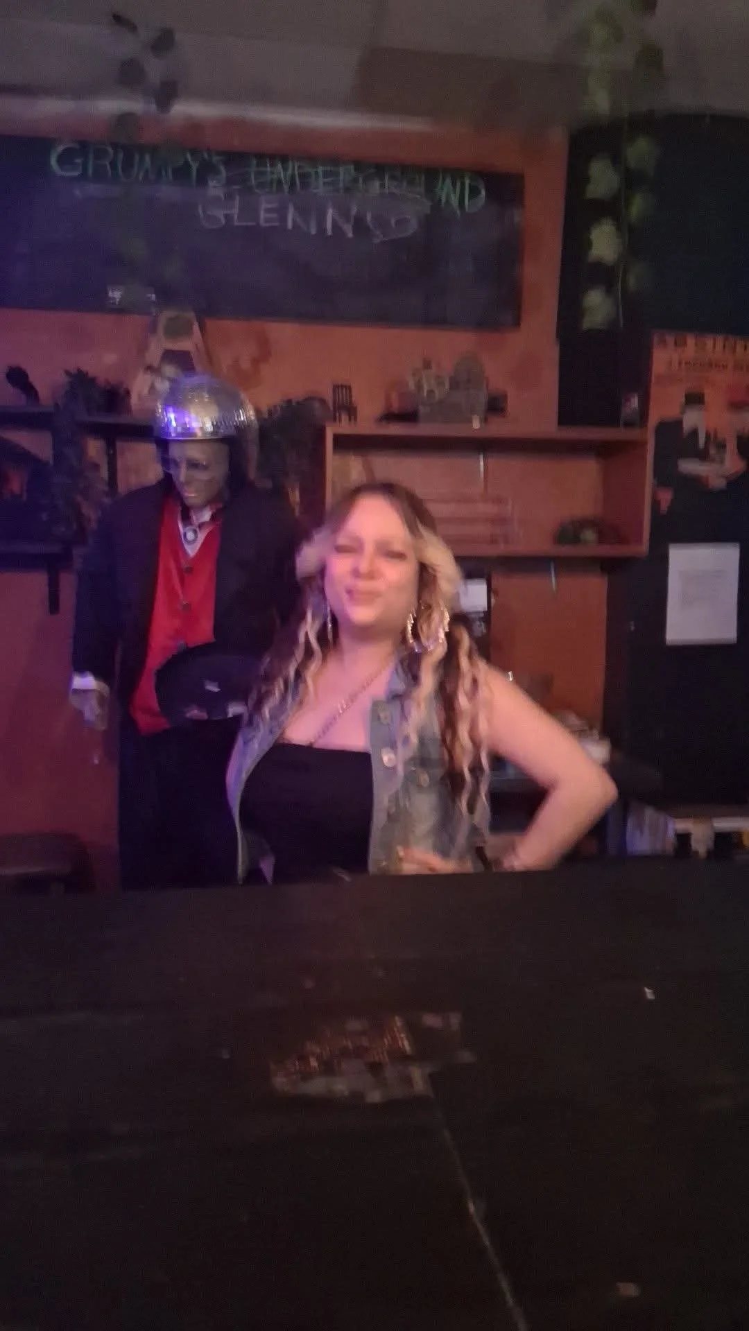 Tiny posing behind the bar with Grumpy’s landmark statue behind her